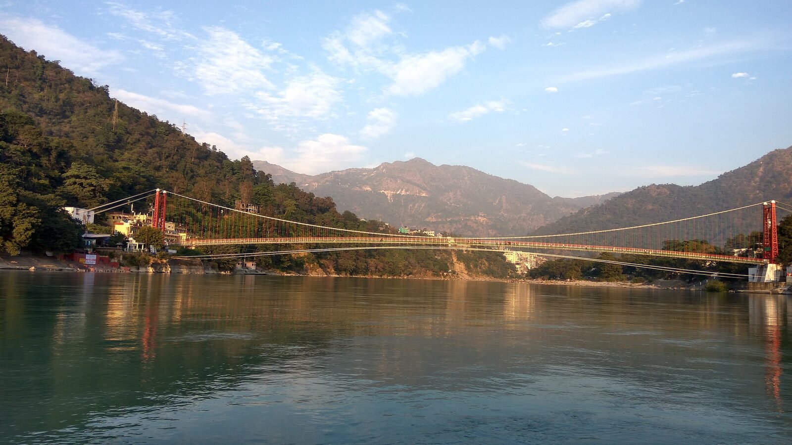 The Ganges flowing beneath the forested Himalayan foothills at Rishikesh