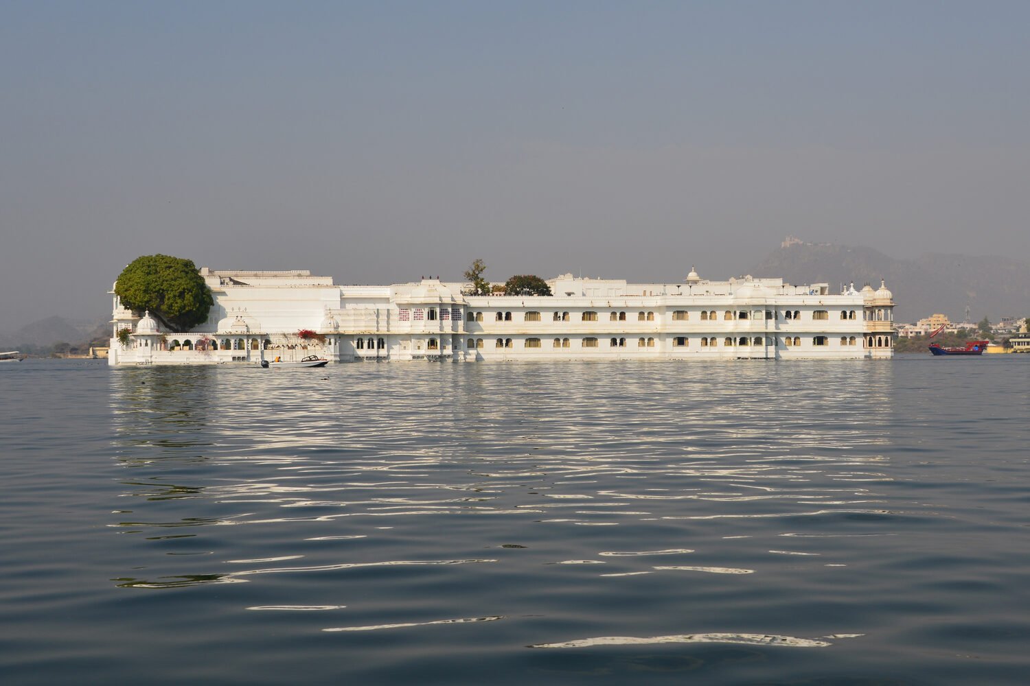 A white palace mirrored in the calm waters of Lake Pichola, Udaipur