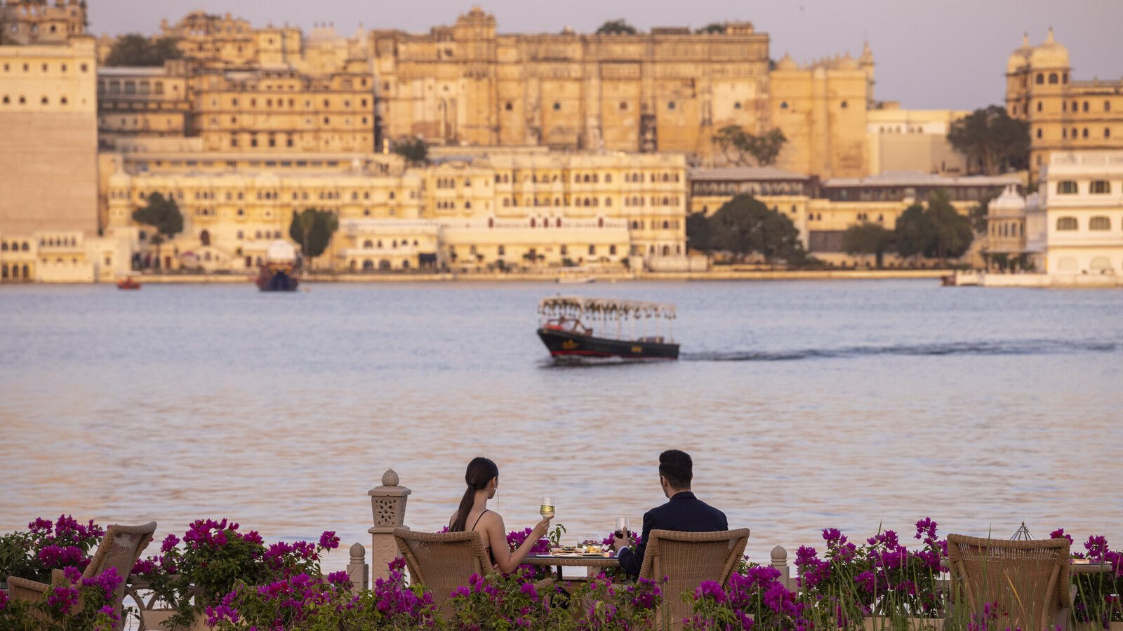A private lakeside dinner overlooking Udaipur’s City Palace across Lake Pichola at dusk