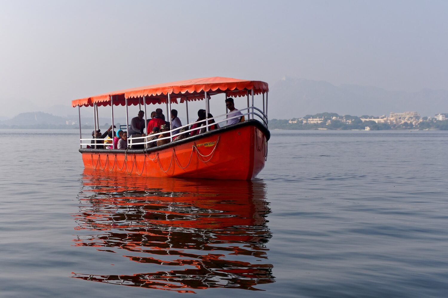 A traditional boat crossing Lake Pichola toward Udaipur's palaces