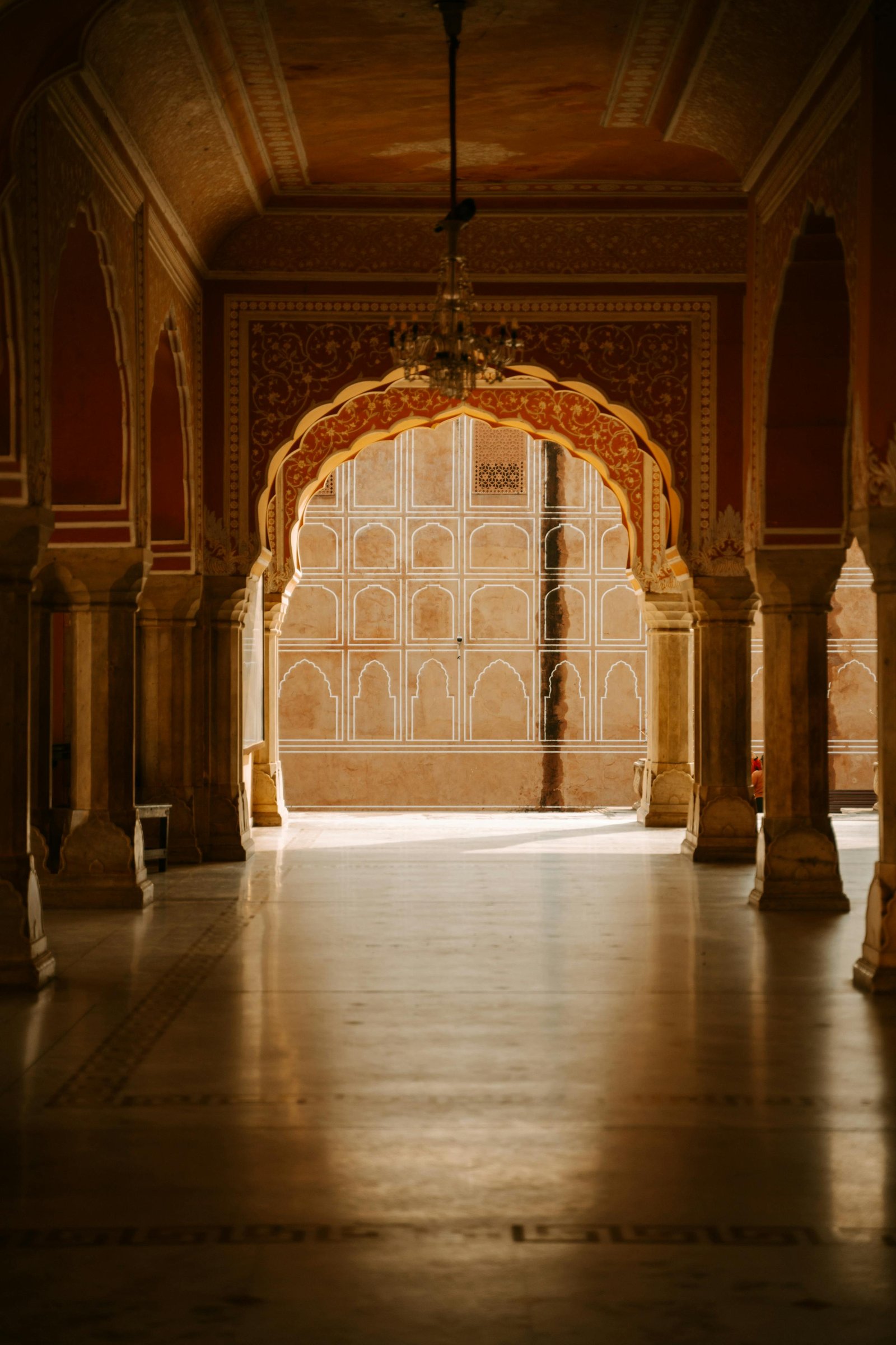 A grand ornate hall of the City Palace in Jaipur lit by warm afternoon light
